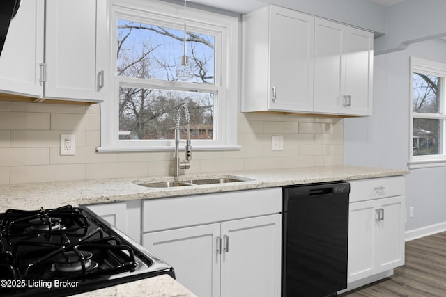 kitchen with tasteful backsplash, white cabinetry, a sink, wood finished floors, and black appliances