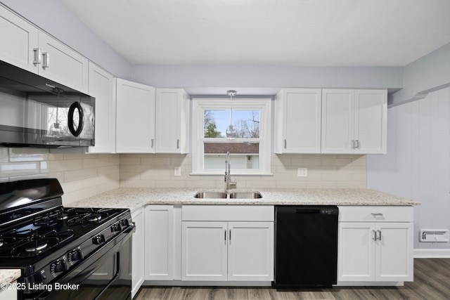 kitchen featuring black appliances, a sink, and white cabinets