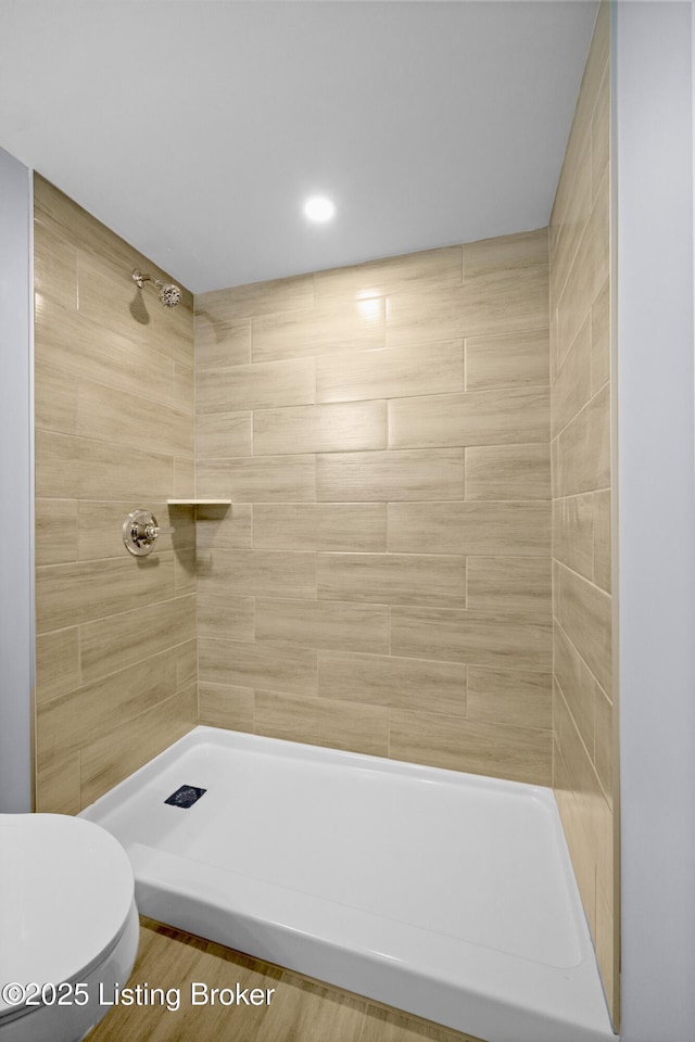 bathroom featuring a tile shower and toilet