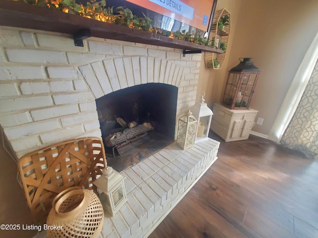 details featuring a fireplace, baseboards, and wood finished floors