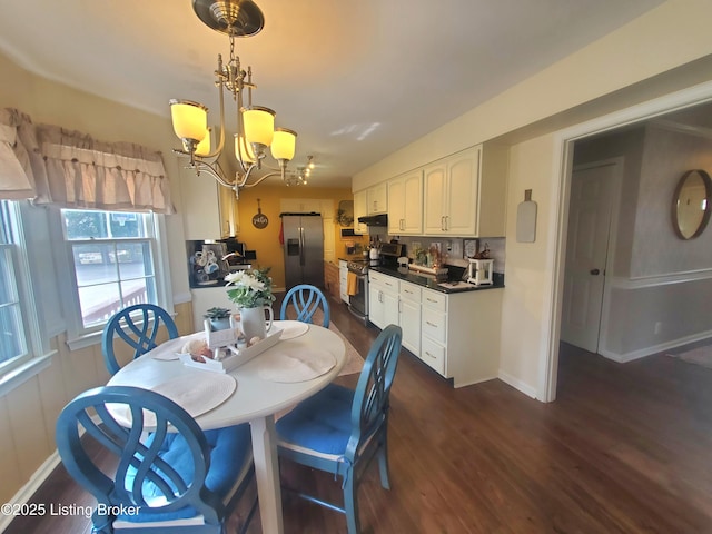 dining area with baseboards, a chandelier, and dark wood finished floors