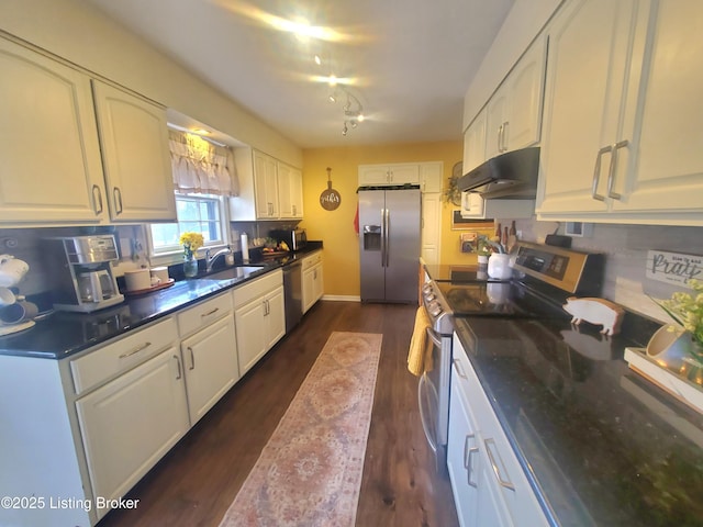 kitchen featuring stainless steel appliances, white cabinets, under cabinet range hood, and decorative backsplash