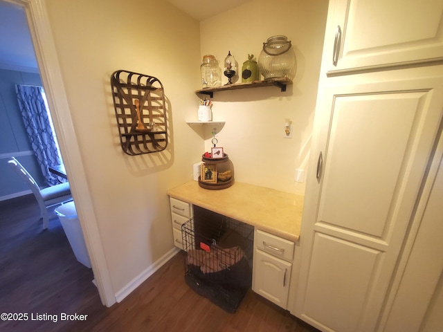 office space with baseboards, dark wood-type flooring, and built in study area