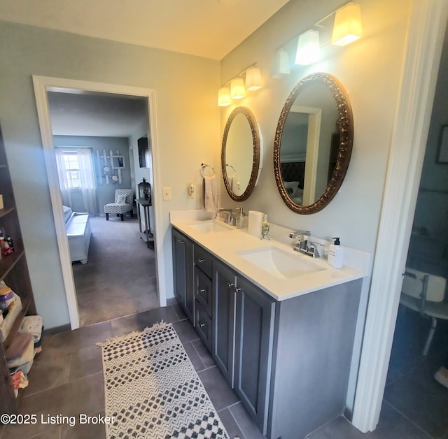 ensuite bathroom with ensuite bathroom, double vanity, a sink, and tile patterned floors