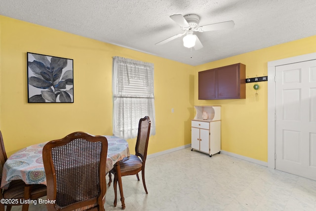 dining room featuring a ceiling fan, a textured ceiling, and baseboards