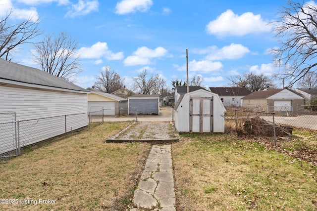 view of yard with an outbuilding, a storage unit, and a fenced backyard