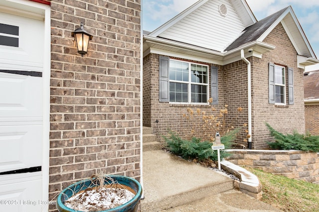 exterior space featuring a garage and brick siding