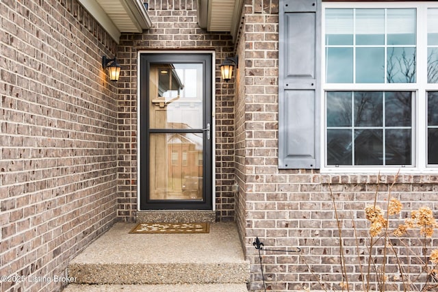 doorway to property featuring brick siding