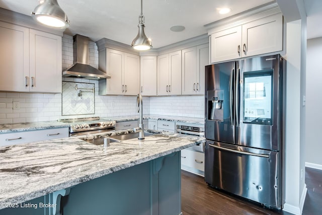 kitchen with light stone countertops, wall chimney range hood, stainless steel appliances, and dark wood-type flooring