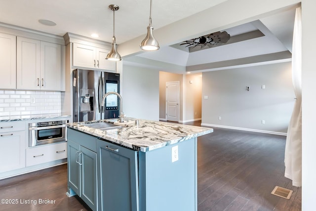 kitchen with stainless steel appliances, dark wood-style flooring, a sink, and decorative backsplash