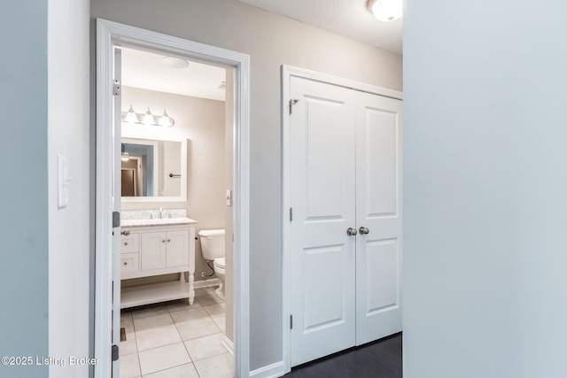 bathroom featuring baseboards, vanity, toilet, and tile patterned floors