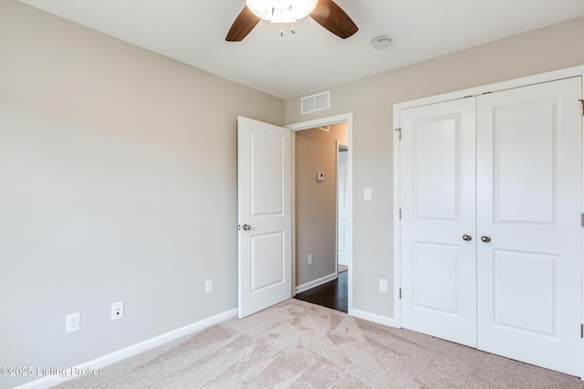 unfurnished bedroom featuring a closet, carpet flooring, visible vents, and baseboards