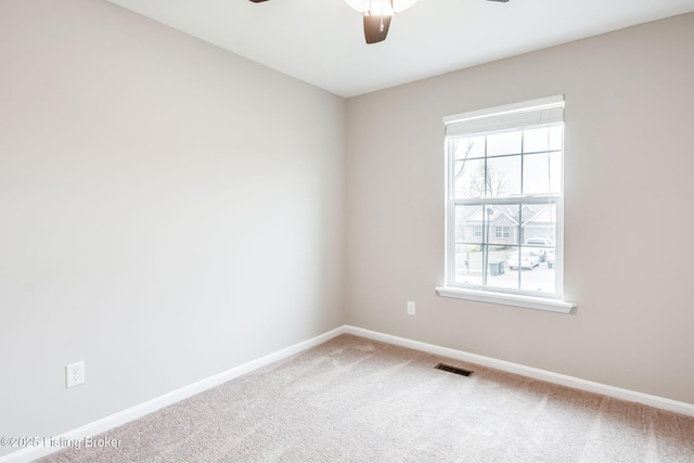 empty room featuring a ceiling fan, baseboards, visible vents, and carpet flooring