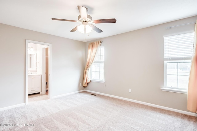 empty room featuring light carpet, visible vents, and baseboards