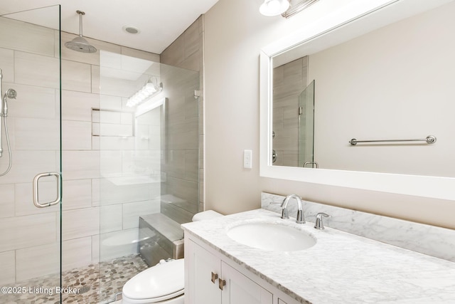 full bath featuring a stall shower, vanity, and toilet