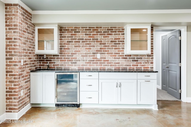 kitchen with glass insert cabinets, beverage cooler, white cabinets, and ornamental molding