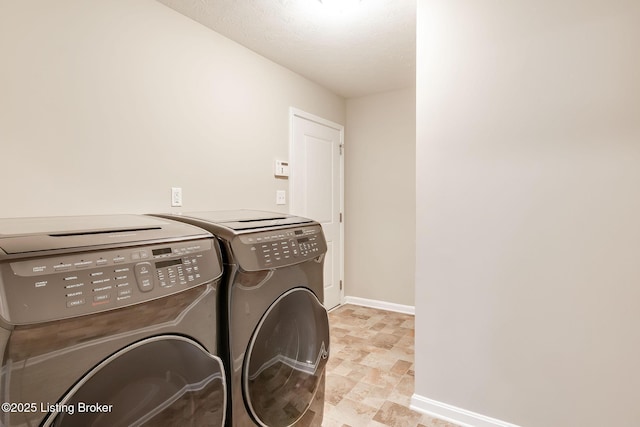 clothes washing area featuring laundry area, washer and clothes dryer, and baseboards