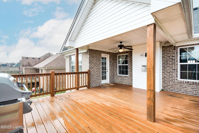 wooden deck with a ceiling fan and a grill