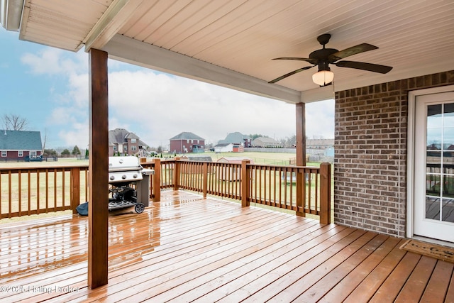 wooden deck with a residential view, a ceiling fan, and area for grilling