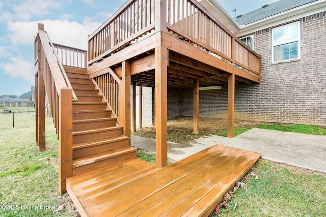 wooden terrace featuring a yard, fence, and stairs