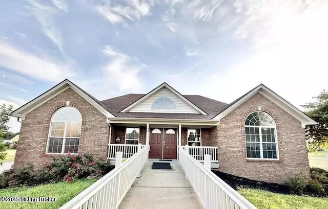 single story home with a porch and brick siding