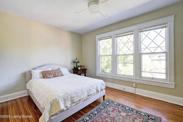 bedroom featuring ceiling fan, baseboards, and wood finished floors