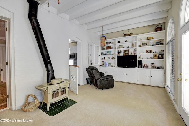 living room featuring a wood stove, light carpet, arched walkways, and beam ceiling