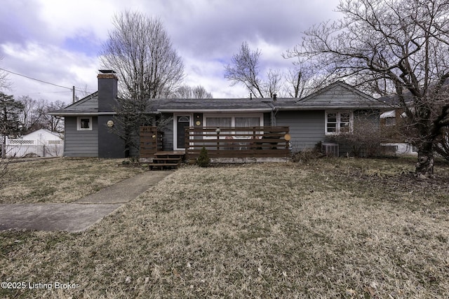 view of front facade with a chimney, fence, and a front lawn