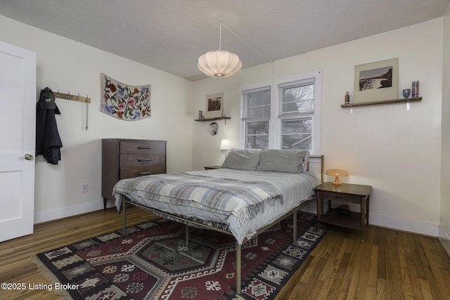 bedroom featuring baseboards and wood finished floors