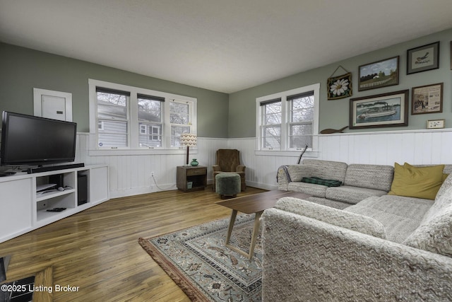 living area with wainscoting and wood finished floors