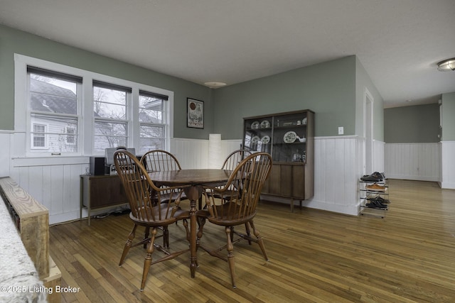 dining space featuring a wainscoted wall and hardwood / wood-style floors