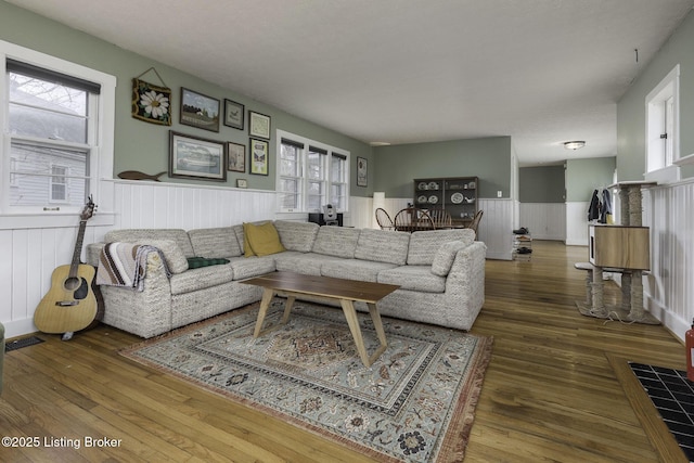 living area with a wainscoted wall and wood finished floors