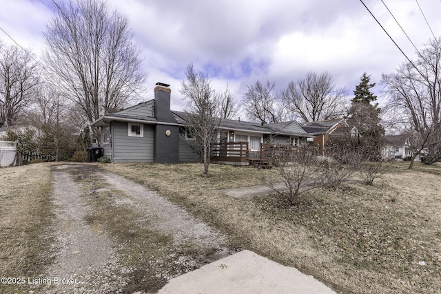 view of front of property featuring a deck, driveway, and a chimney