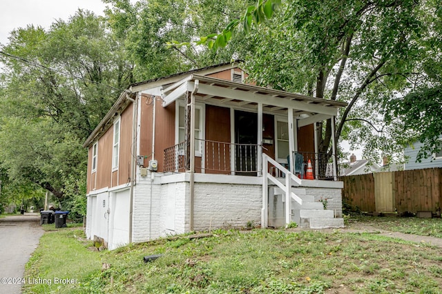 view of front facade featuring covered porch and fence