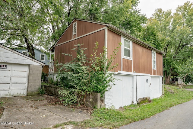 view of side of property featuring a garage and an outbuilding