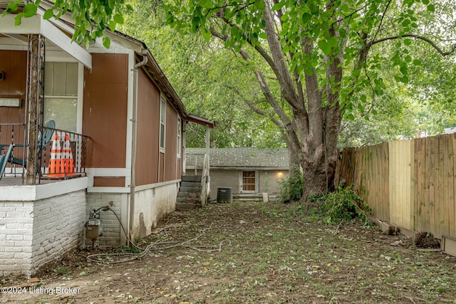 view of property exterior with cooling unit and fence