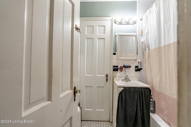 full bath with backsplash, vanity, and shower / bath combo with shower curtain