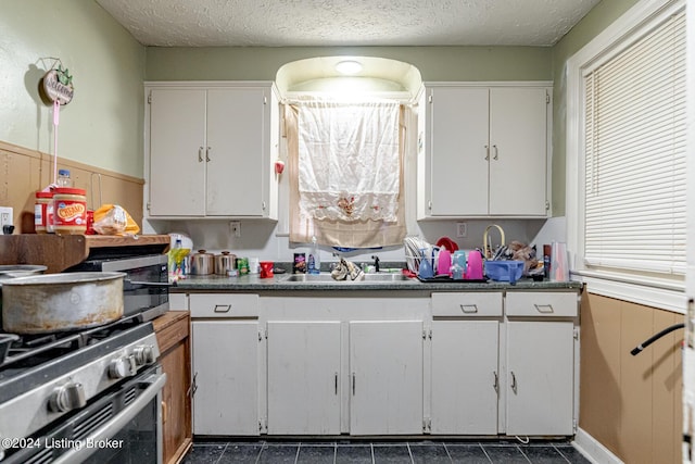 kitchen featuring stainless steel appliances, white cabinets, a sink, and a textured ceiling