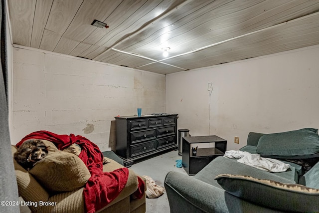 interior space with concrete block wall, wooden ceiling, and concrete floors