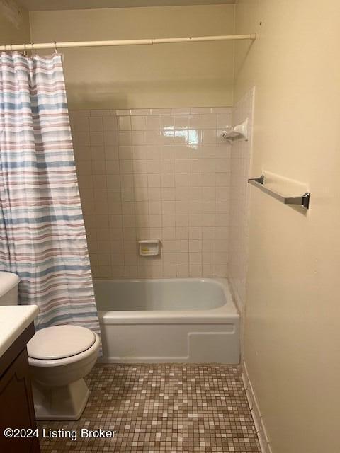 bathroom with toilet, tile patterned flooring, shower / bath combination with curtain, and vanity