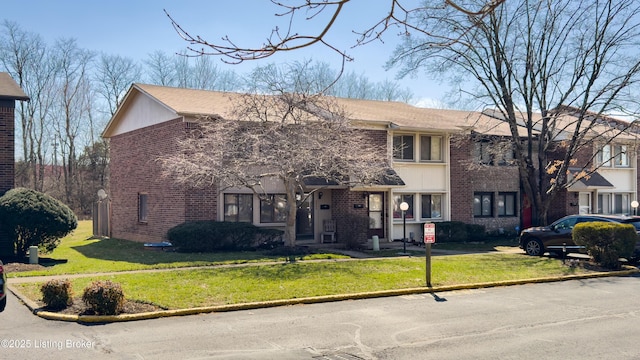 view of front of property with brick siding and a front yard