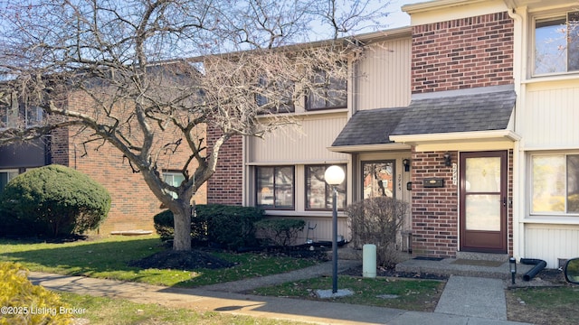 townhome / multi-family property featuring brick siding and a shingled roof