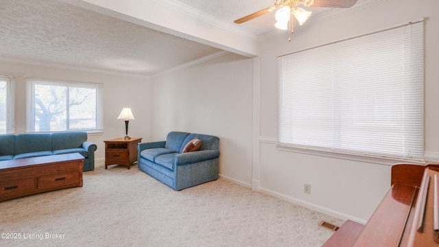 living room with visible vents, baseboards, ornamental molding, carpet floors, and a textured ceiling