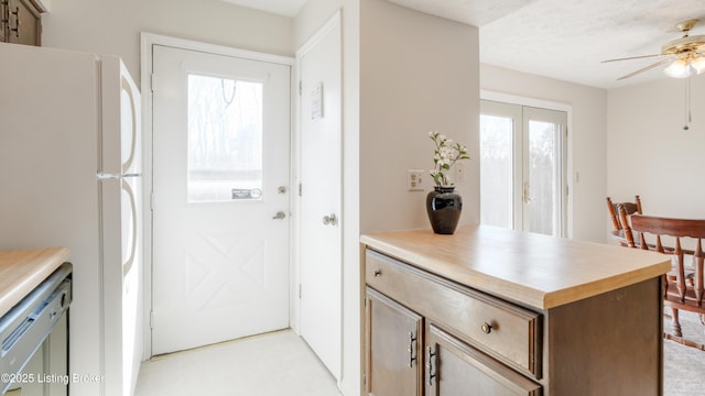 kitchen featuring plenty of natural light, dishwasher, light countertops, and freestanding refrigerator