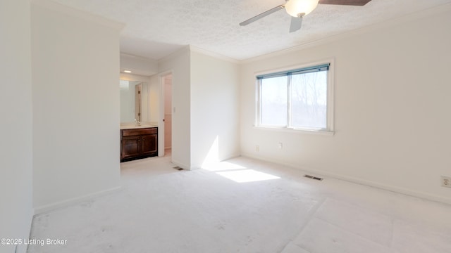 unfurnished bedroom with visible vents, a textured ceiling, crown molding, and baseboards