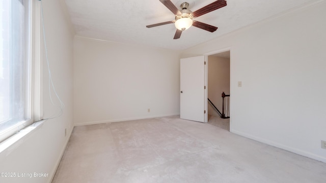 spare room with ceiling fan and baseboards