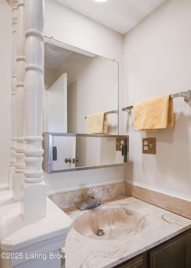 bathroom featuring a textured ceiling and vanity