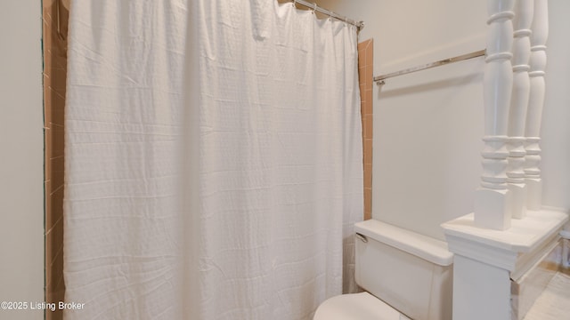 bathroom with a shower with curtain and toilet