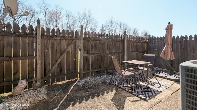 view of patio / terrace with central air condition unit, outdoor dining area, and a fenced backyard