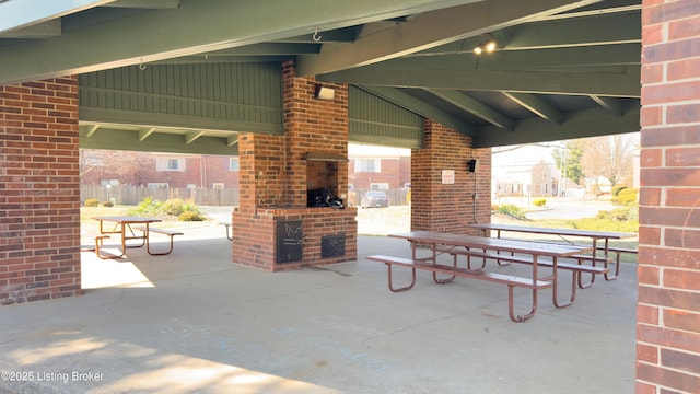 view of patio / terrace featuring a fireplace and fence